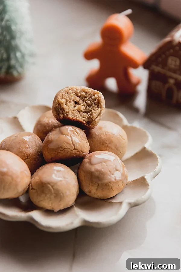 Pile of delectable gingerbread donut holes, one with a bite taken, showcasing their soft interior.
