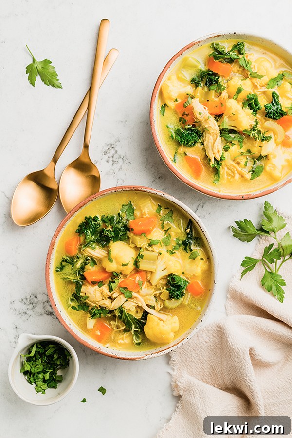 Multiple bowls of turmeric chicken soup.