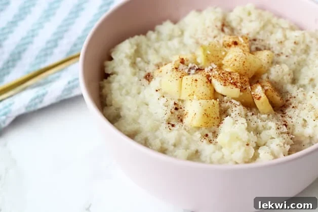 This inviting image features a rustic, textured bowl brimming with Grain-Free Cauliflower "Oatmeal." The creamy, rich consistency is evident, suggesting a satisfying and comforting breakfast. The dish is subtly garnished, hinting at natural flavors and wholesome ingredients. It’s a perfect visual representation of a healthy, delicious, and diet-friendly meal suitable for Paleo, AIP, and Whole30 lifestyles.