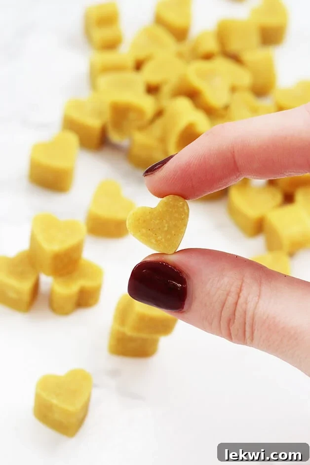 A stack of turmeric chewables with a hand holding one, showcasing the texture and vibrant color.