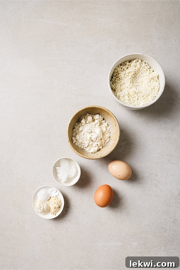 A selection of essential ingredients for cauliflower veggie nuggets: coconut flour, eggs, and tapioca starch, laid out on a clean surface.