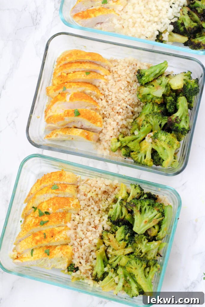 Two glass meal prep containers filled with turmeric chicken, cauliflower rice, and roasted broccoli.