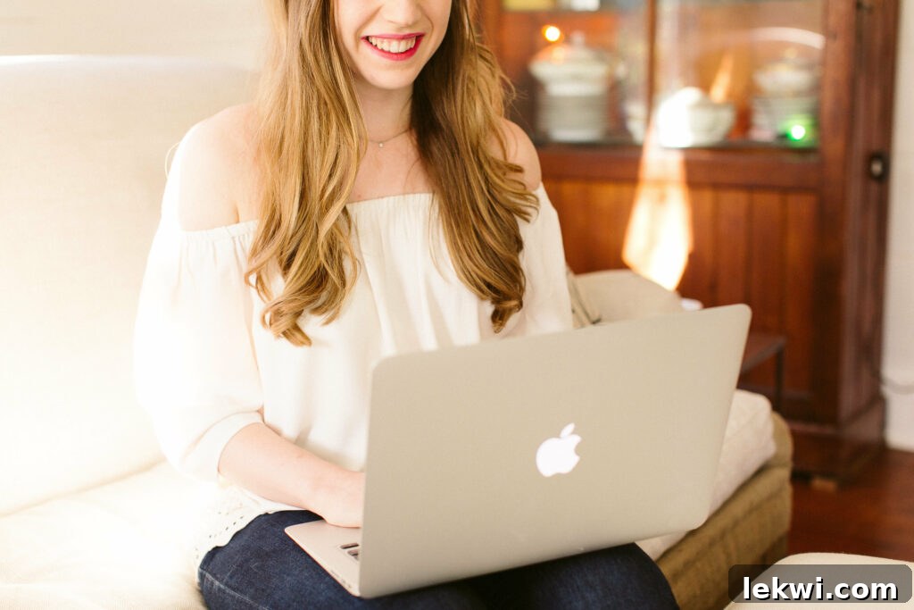 A photo of Michelle in a white top and jeans working at her laptop, engaged in content planning for her blog.