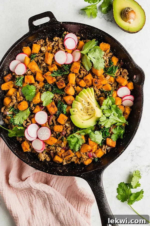 Creamy avocado slices beautifully arranged on a serving of Mexican-inspired breakfast skillet.