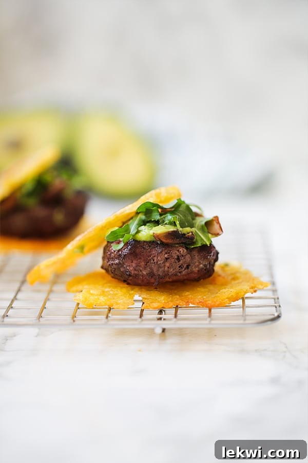 A tostone slider topped with avocado and greens on a wire rack.