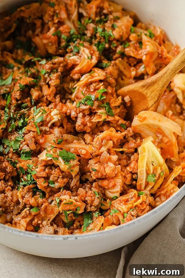 Unstuffed cabbage roll in a dutch oven with a wooden spoon.