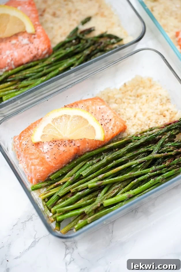 Three glass meal prep containers, each perfectly portioned with roasted salmon, crisp asparagus, and fluffy cauliflower rice. Text overlay reads 'Salmon Meal Prep Bowls Paleo AIP Whole30'.