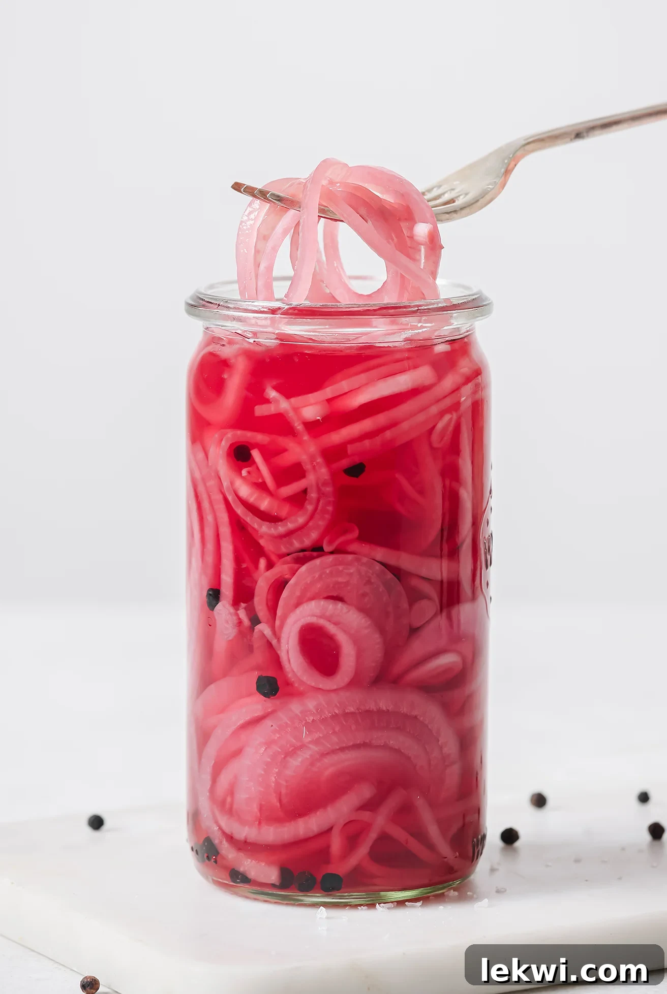 Apple cider vinegar pickled onions in a jar with a fork, ready to eat.