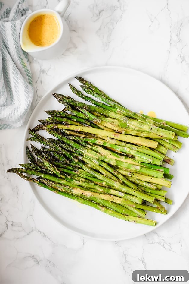 A white plate filled with roasted asparagus.