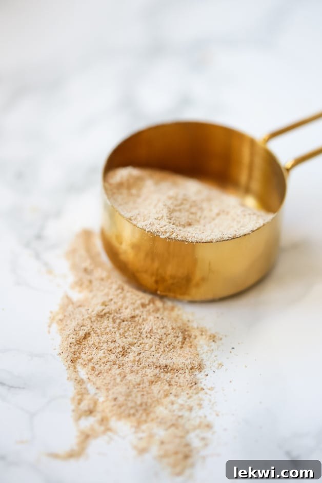 A measuring cup with tigernut flour in it and around it.