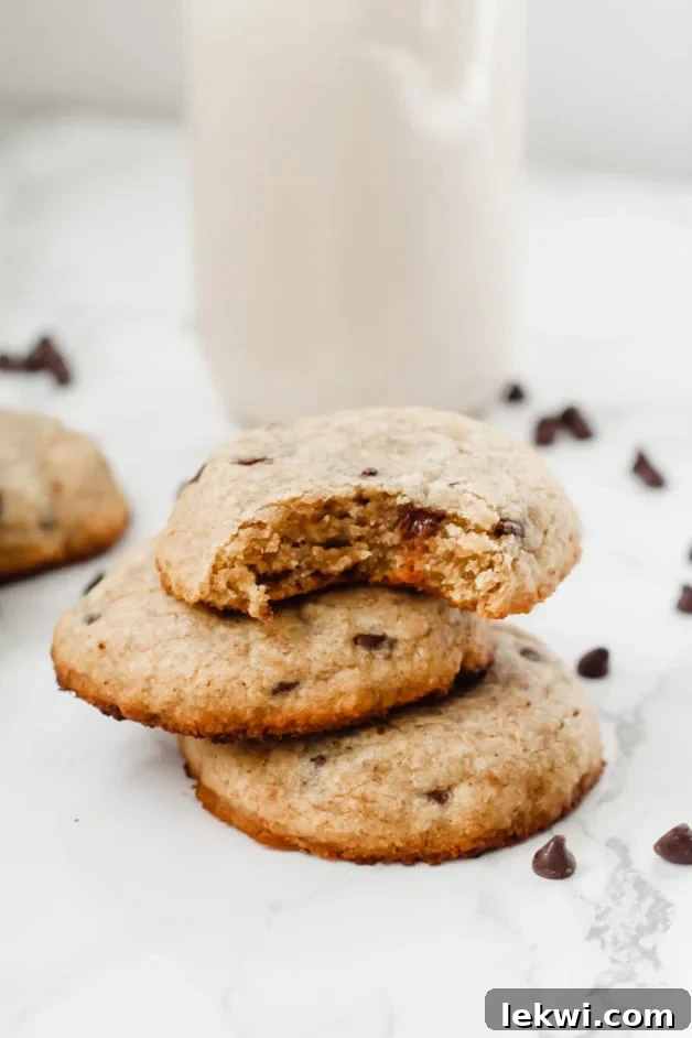 A stack of three cookies with a bite taken out of the top one.