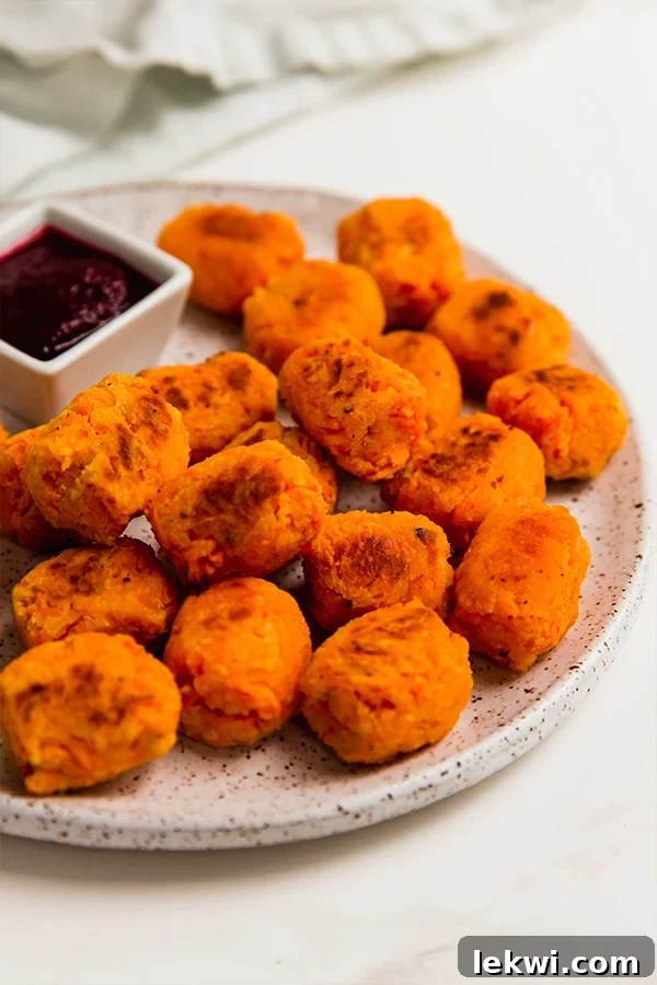 Plate of sweet potato tater tots with a bowl of dip.