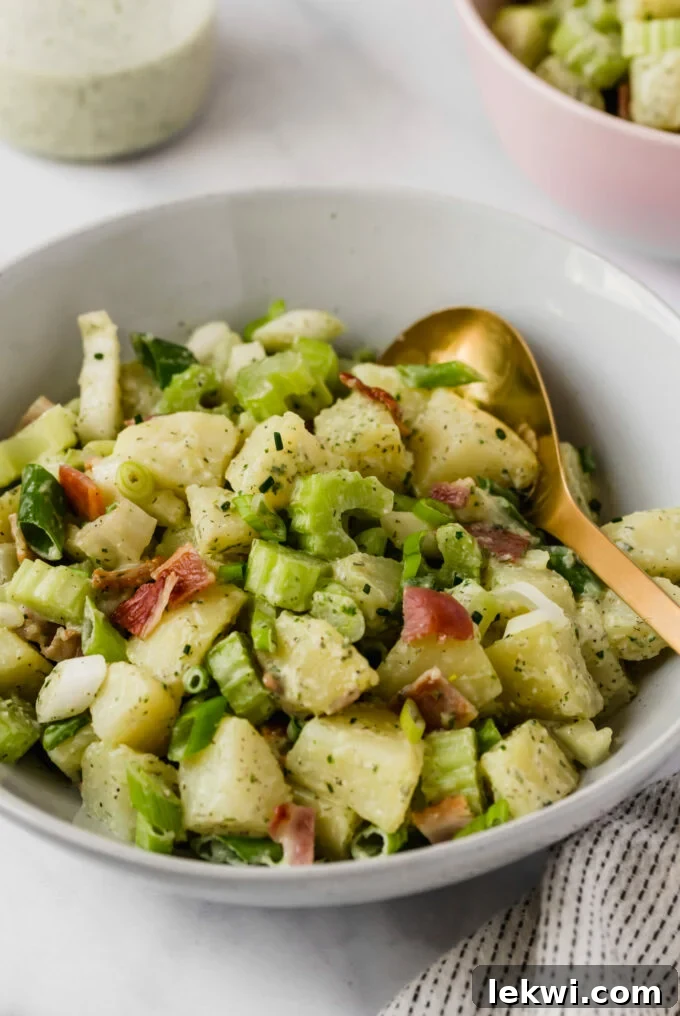 A white bowl filled with bacon ranch sweet potato salad.