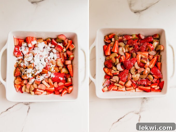 Freshly sliced strawberries and neatly chopped rhubarb, glistening with thickening agents and natural sweeteners, meticulously arranged in a baking dish, forming the crisp's delicious foundation.