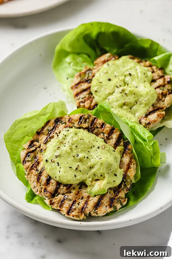 Spinach Avocado Chicken Burgers served on fresh lettuce wraps, emphasizing their healthy, bun-free presentation for Paleo, Whole30, and AIP diets.