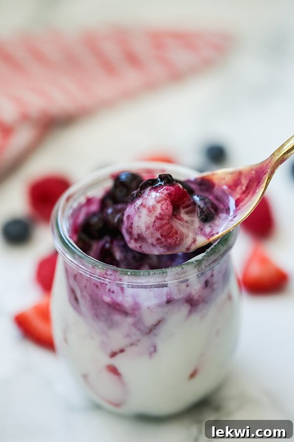 Top-down view of Red, White & Blue Berry Panna Cotta (Paleo, AIP, Dairy Free) in glass jars, garnished with fresh berries.