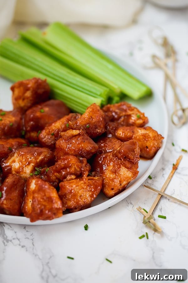 Prepared BBQ Chicken Poppers on a wooden board, ready to be tossed with sauce