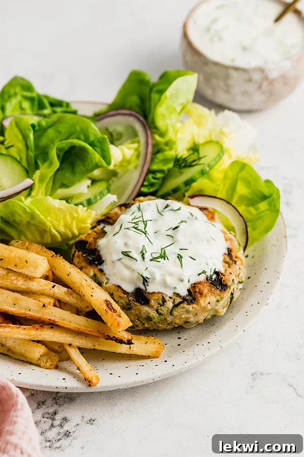 Plate of fries and salad with a Greek chicken burger.
