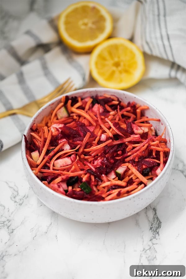 A bowl of detox carrot slaw with a fork next to it.