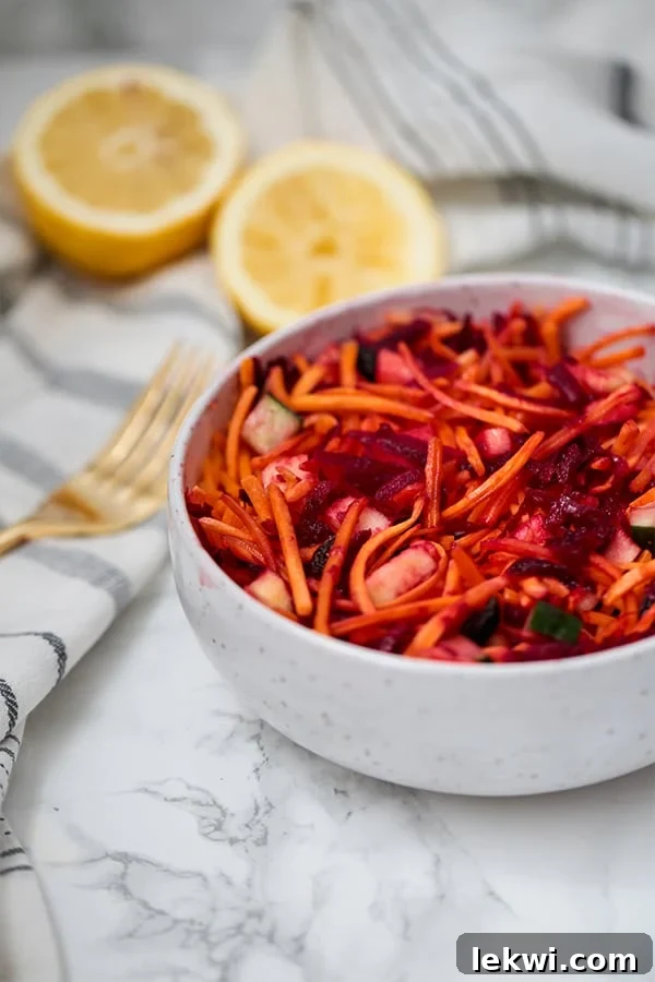 A bowl of detox carrot slaw with a fork next to it.