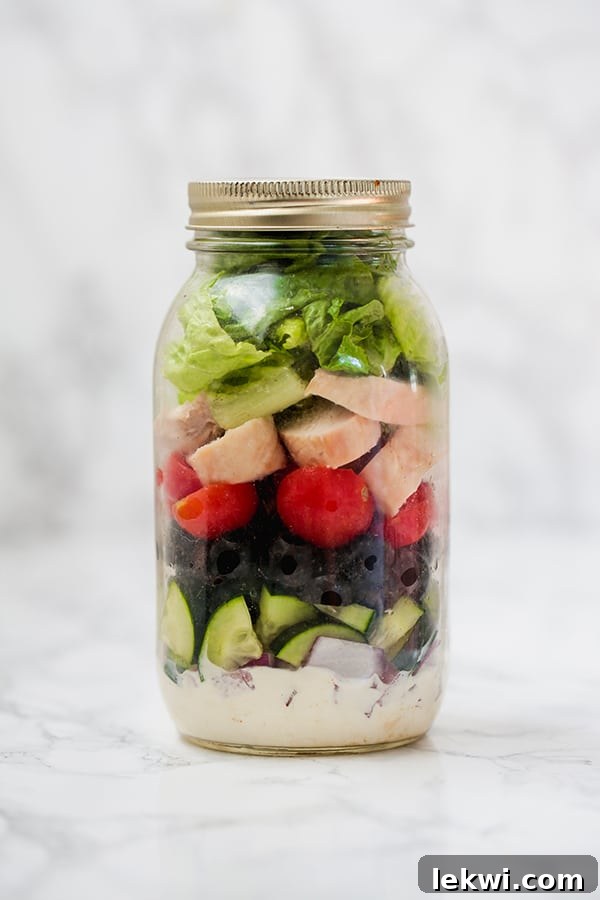 Mason jar Greek salad with dairy-free tzatziki, cucumber, red onion, olives, tomatoes, and chicken