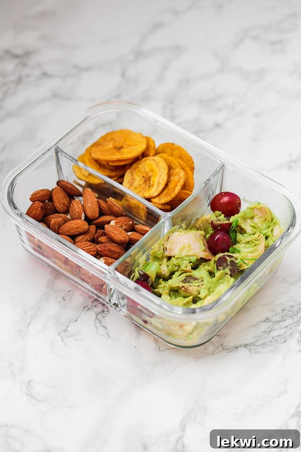 Avocado chicken salad with plantain chips and almonds packed for a healthy paleo lunch.