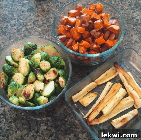 A diverse array of roasted vegetables prepared for meal prep, including Brussels sprouts, parsnip fries, sweet potato hash browns, and various squashes.