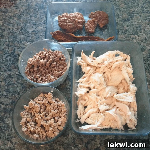 A selection of cooked meats for weekly meal prep, including grass-fed beef burgers, bacon, ground pastured pork, ground bison, and roasted chicken.