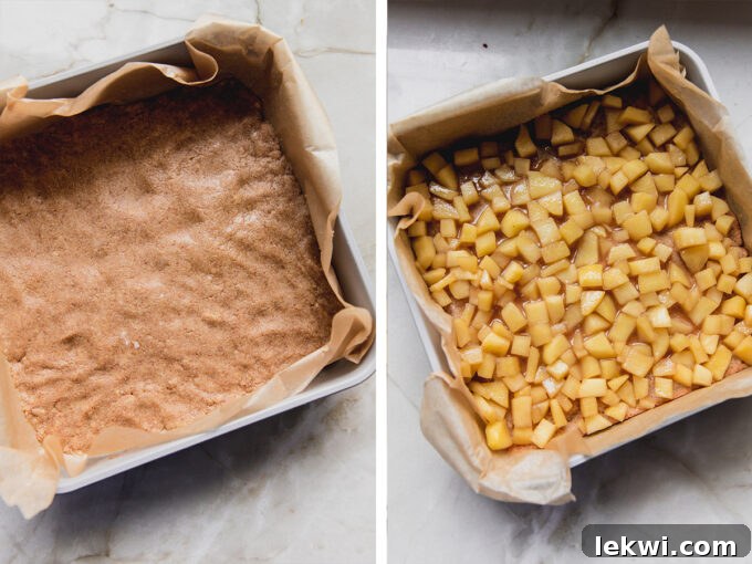 A baking pan filled with a golden brown crust topped with a generous layer of spiced apple filling, ready for the final crumble topping.