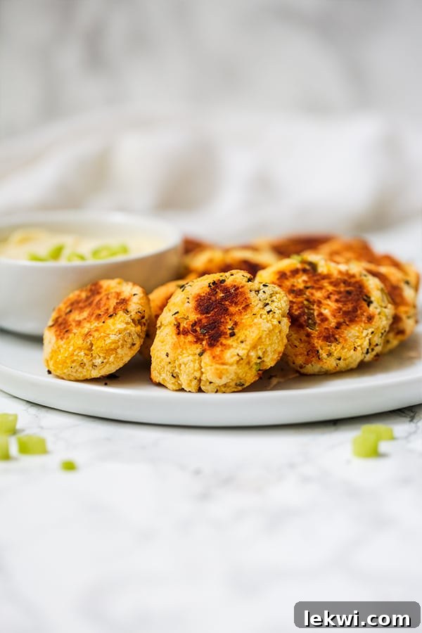 Golden-brown spaghetti squash nuggets piled on a plate, ready to be served as a healthy, veggie-packed snack.