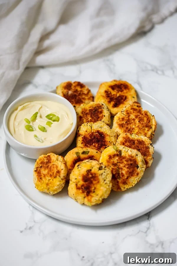 A close-up view of golden, crispy spaghetti squash nuggets cooling on a wire rack after baking, showcasing their perfect texture.