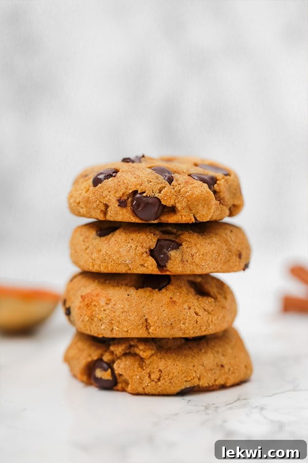 A stack of golden-brown pumpkin chocolate chip cookies, indicating their soft and inviting texture.