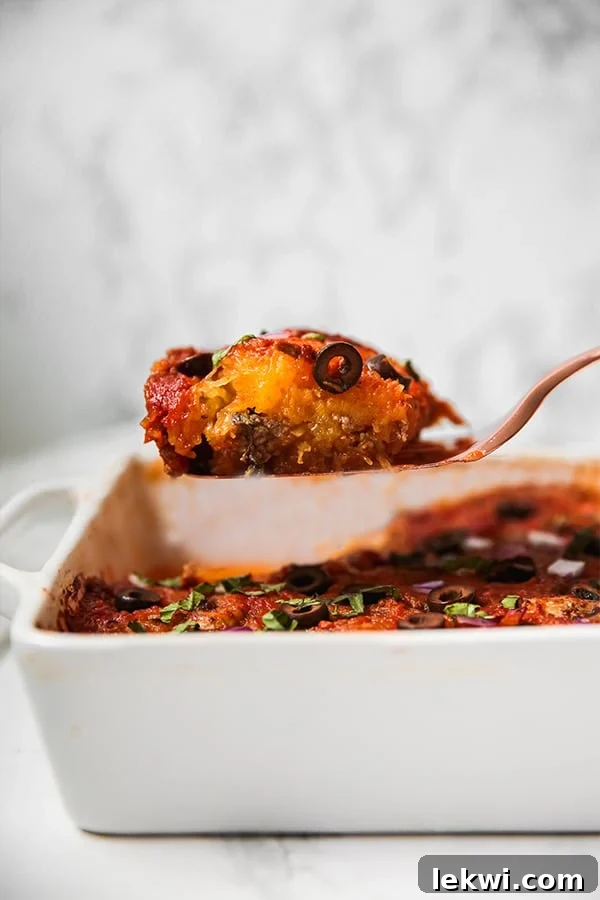 A large serving of spaghetti squash pizza casserole topped with fresh basil and parsley.