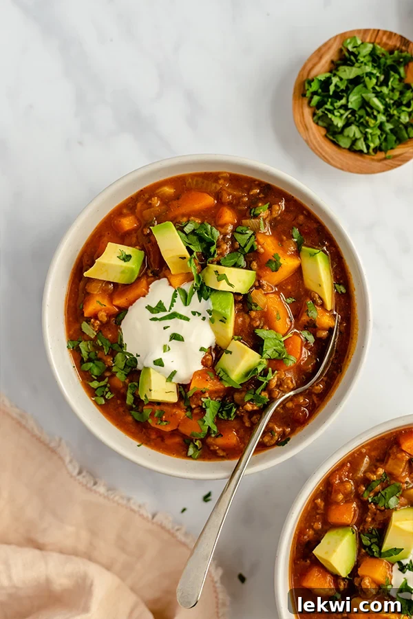 Paleo Pumpkin Chili served in a rustic bowl, garnished with fresh cilantro and avocado