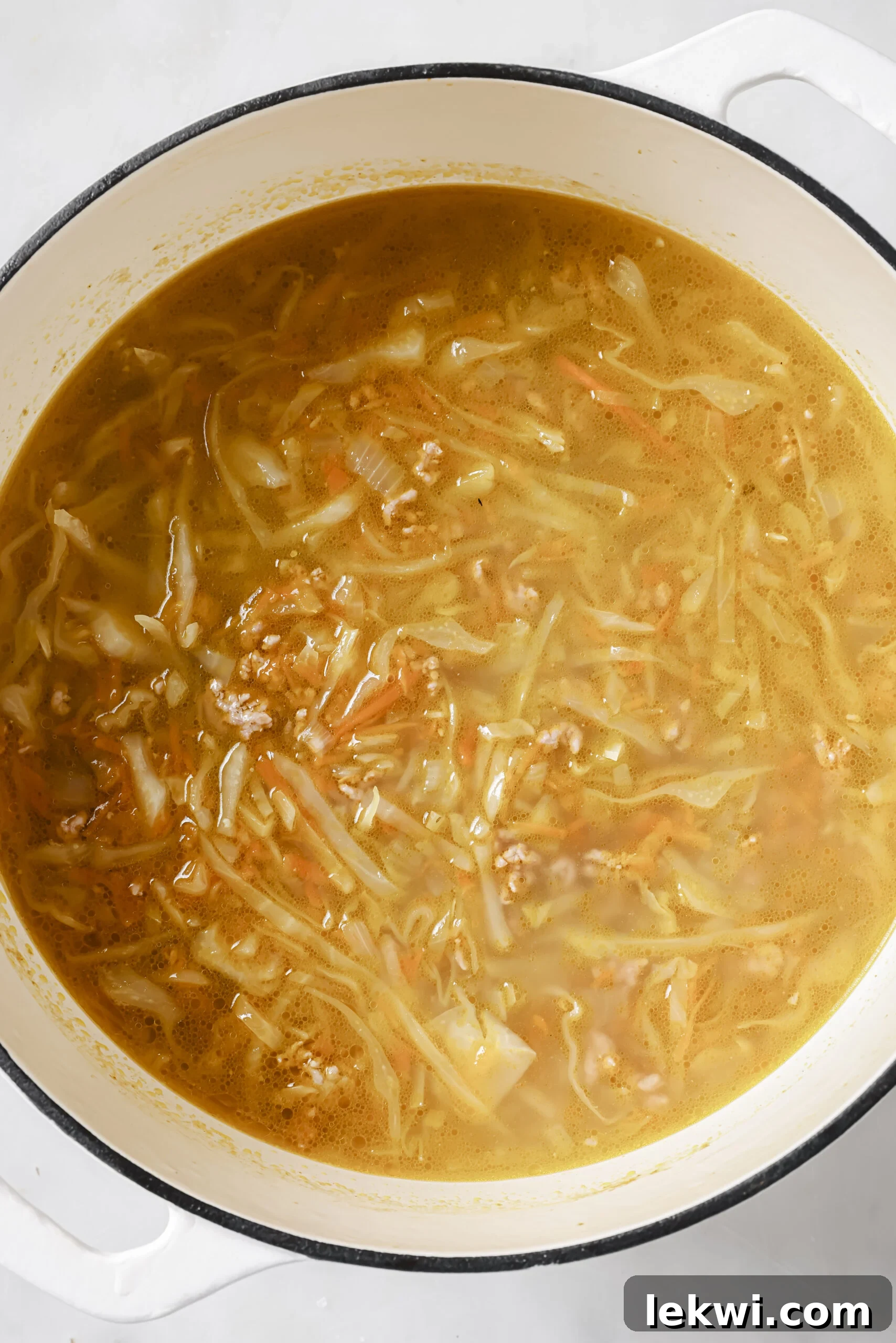 Egg roll soup in a large cast iron pot.