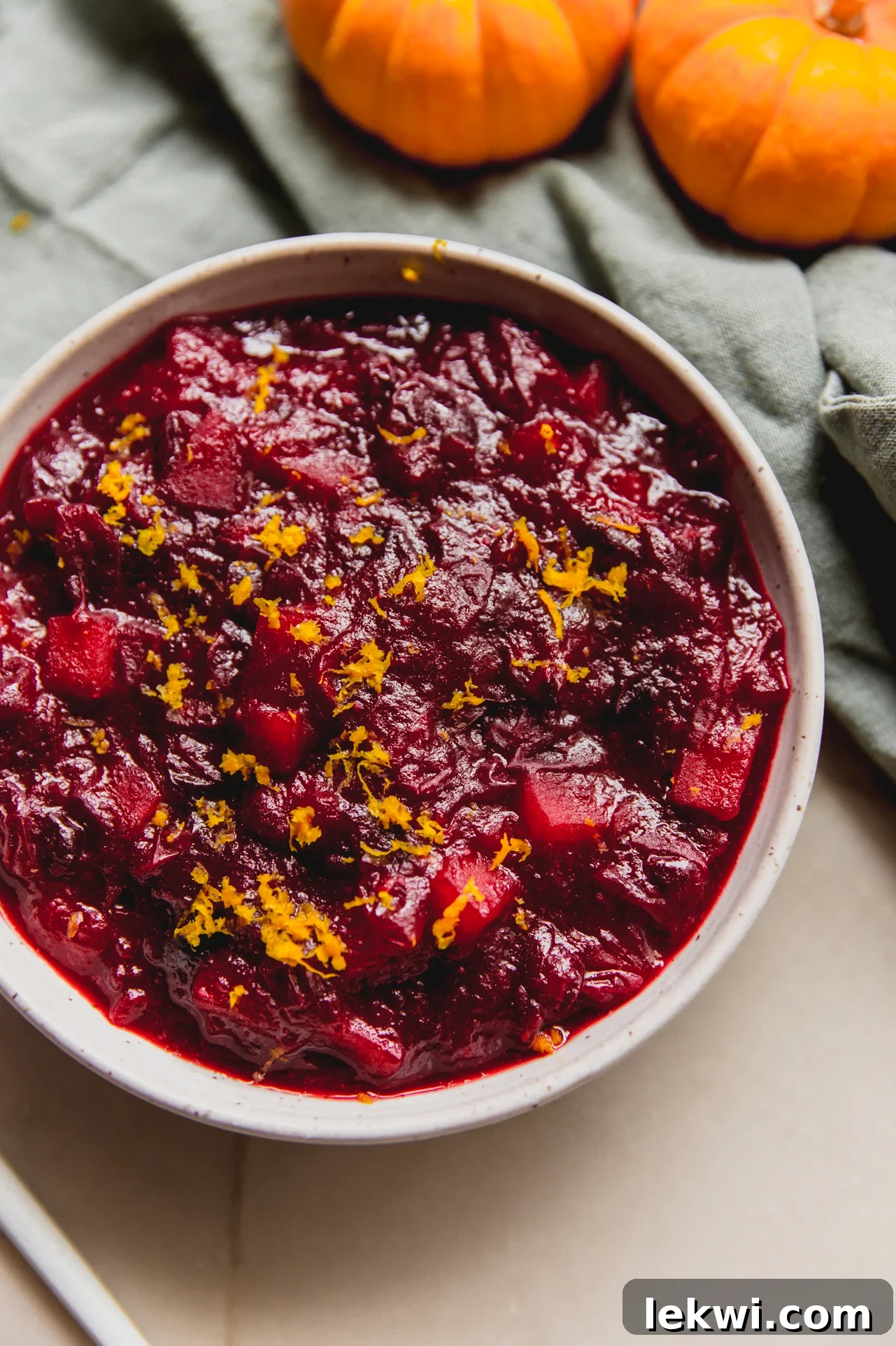 Finished Apple Cranberry Sauce in a bowl topped with orange zest.