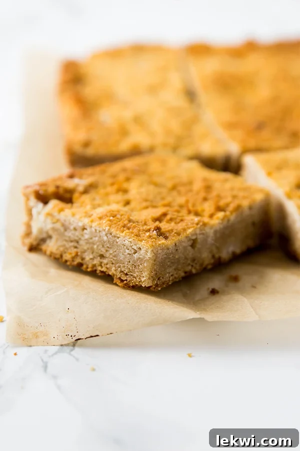 A slice of paleo cornbread being taken out from a pan of cornbread.