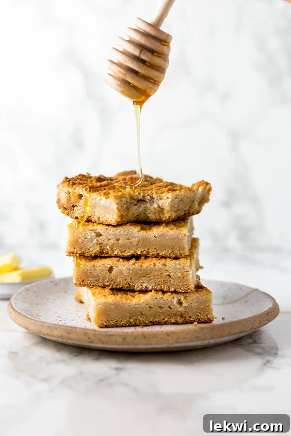 A plate with four slices of grain free paleo cornbread with honey being drizzled over it.