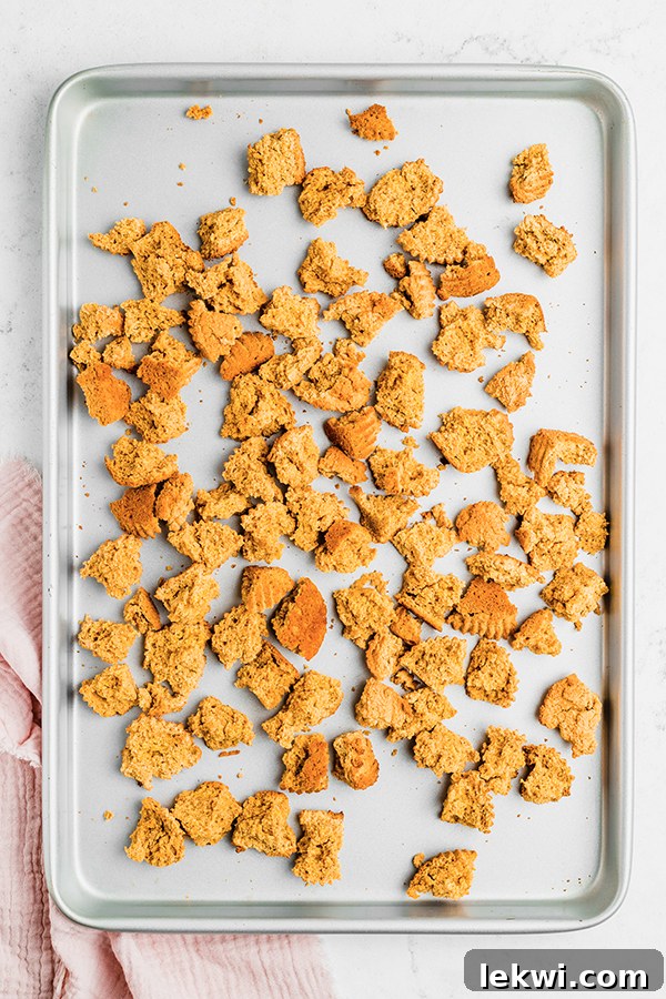 A baking sheet with torn cubes of corn-free cornbread, ready for stuffing.