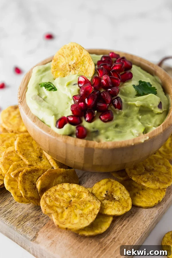Close-up of creamy guacamole with fresh pomegranate seeds.