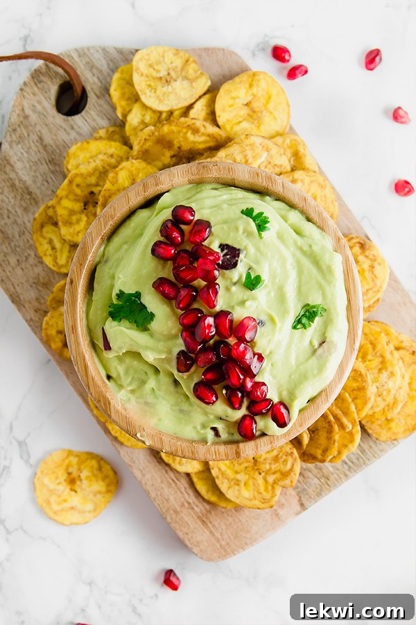 Pomegranate Guacamole in a wooden bowl, ready to be served.