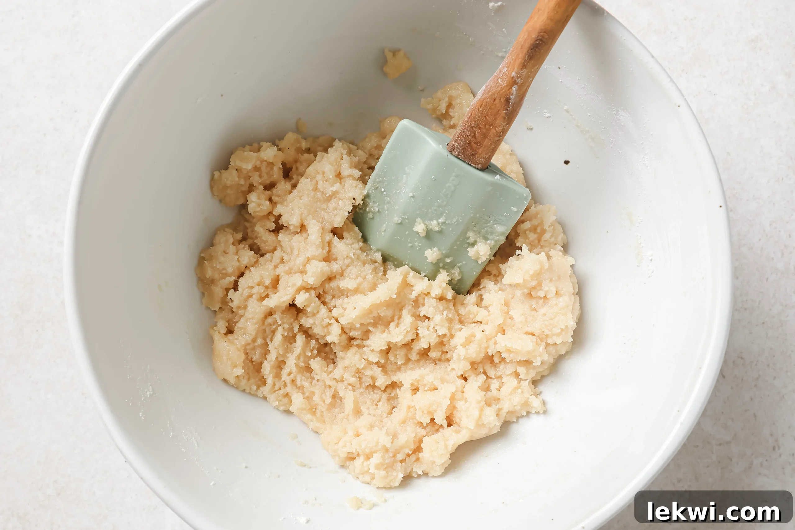 A bowl containing the raw dough for the pumpkin pie bar crust, perfectly mixed and ready for pressing.