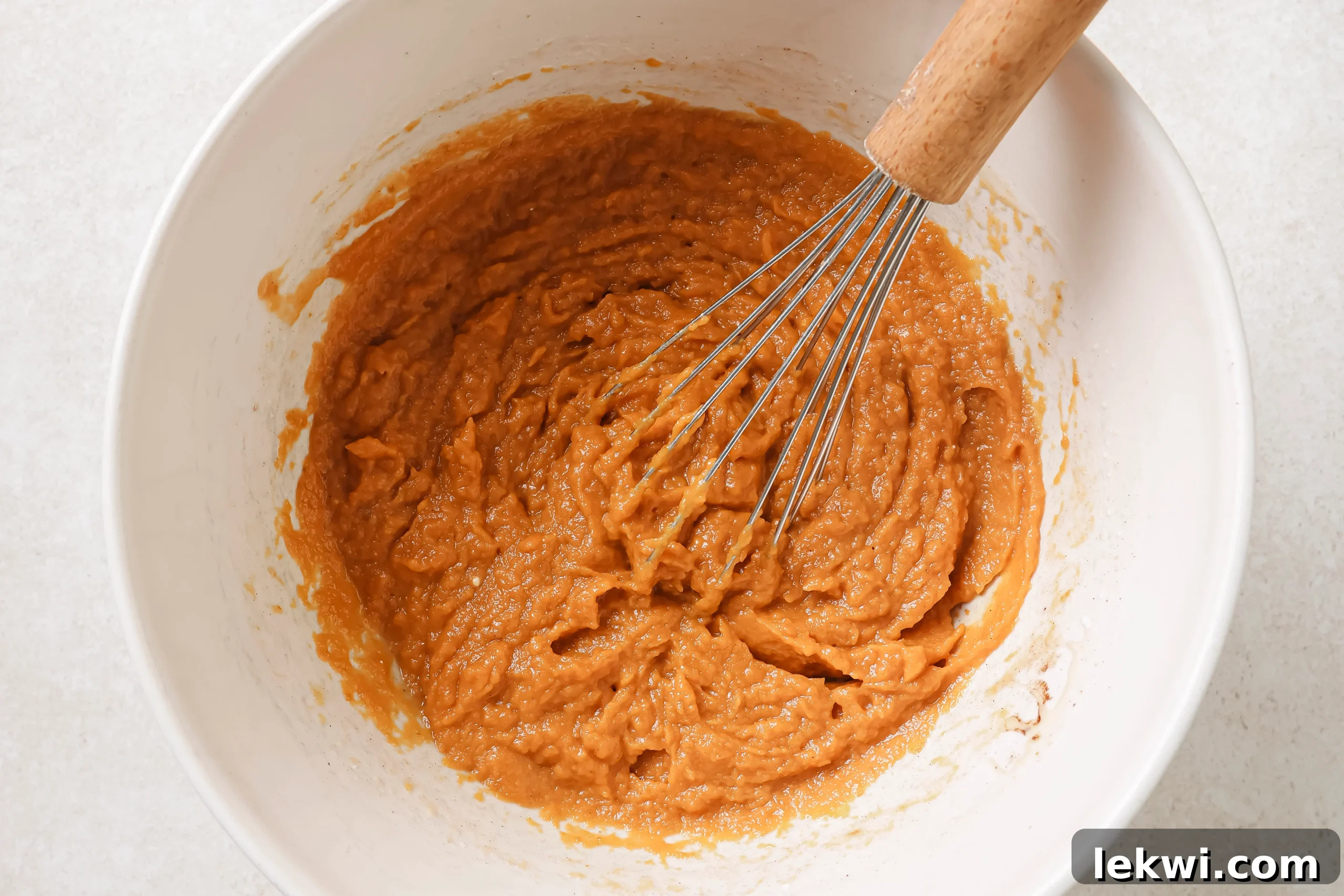 The pumpkin pie bar filling mixture in a bowl, now fully whisked into a smooth and creamy consistency.