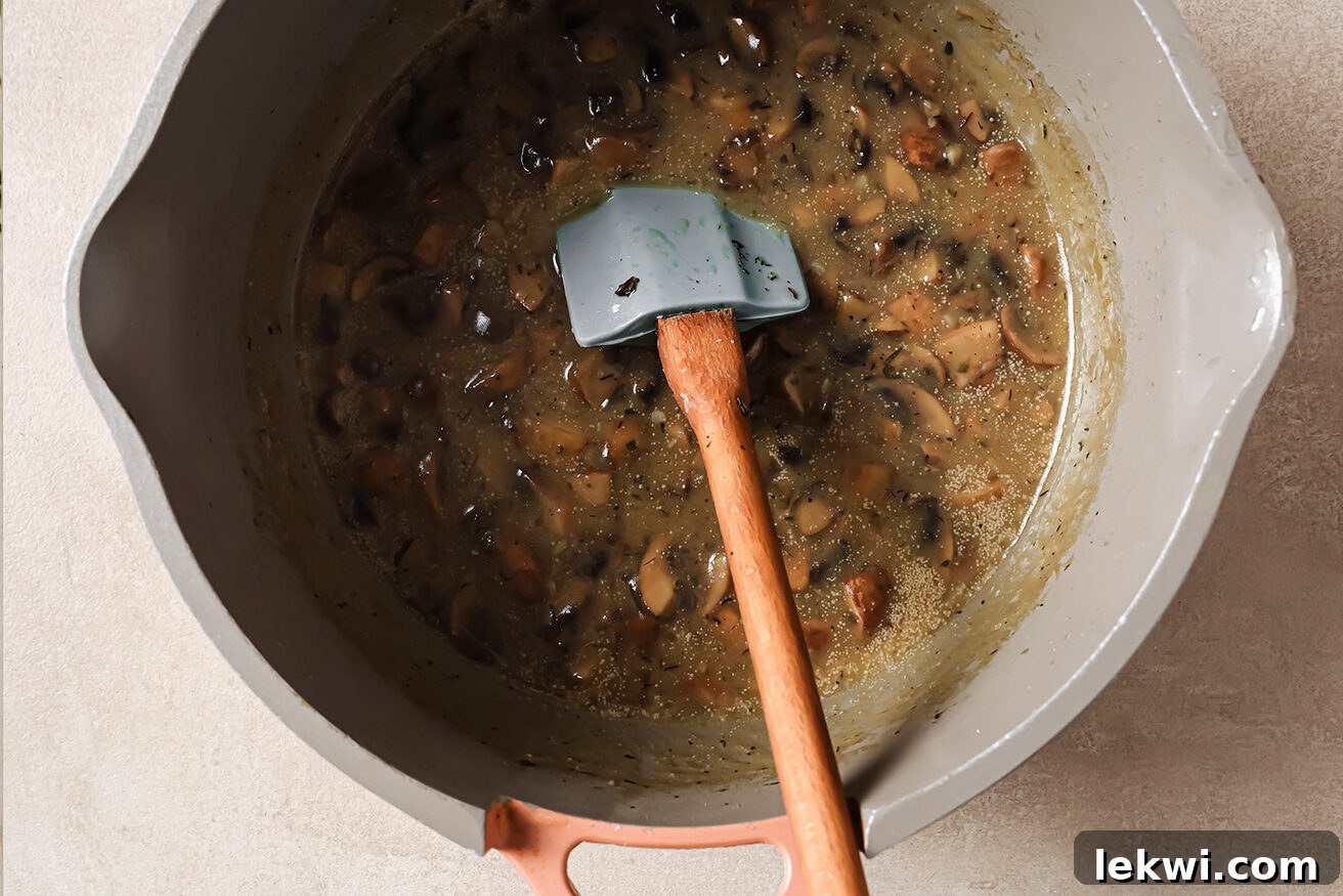 Mushrooms and broth simmering in a pot on the stovetop, releasing their savory aromas.