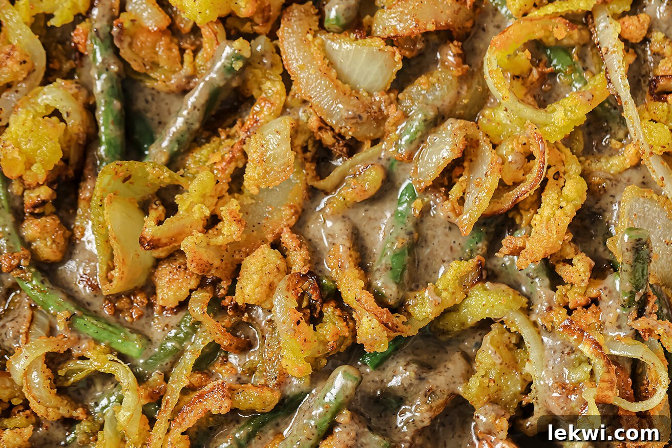 Gluten-free green bean casserole topped with a generous layer of golden-brown fried onions, hot and ready to serve.