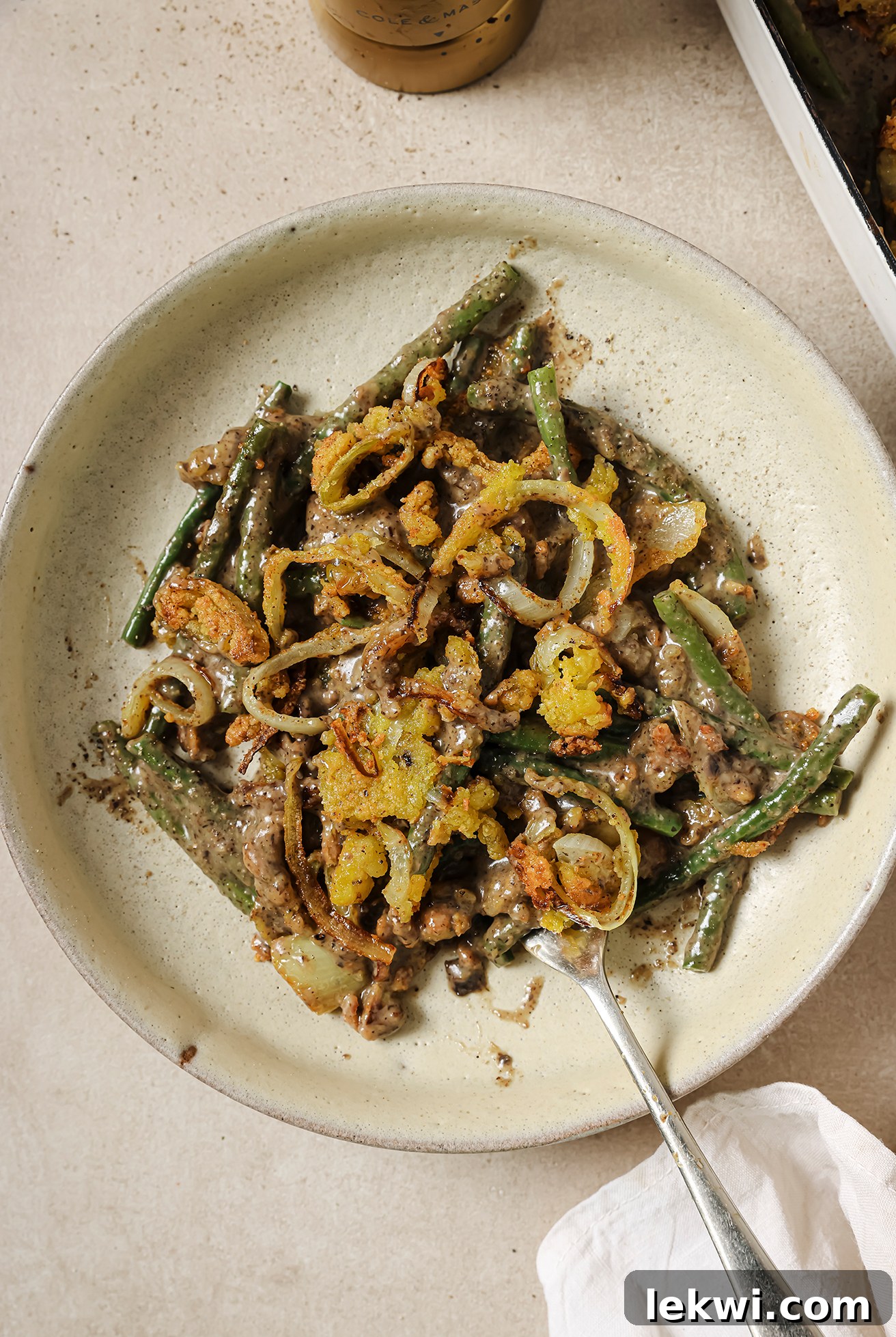 A perfectly portioned serving of gluten-free green bean casserole on a white plate, ready to be enjoyed.