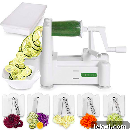 A spiralizer actively making zoodles from a fresh zucchini, illustrating its function.