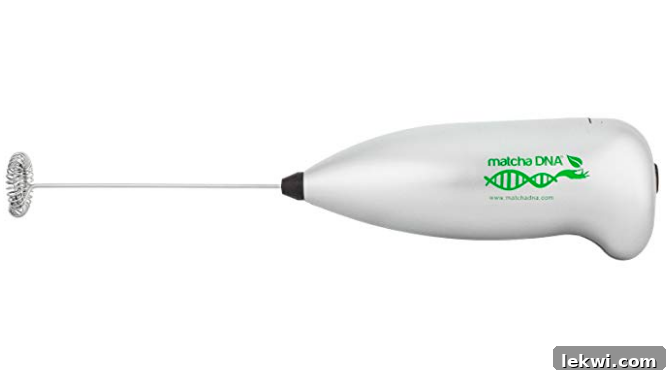 A sleek handheld frother next to a mug, suggesting its use for creamy beverages or other kitchen tasks.