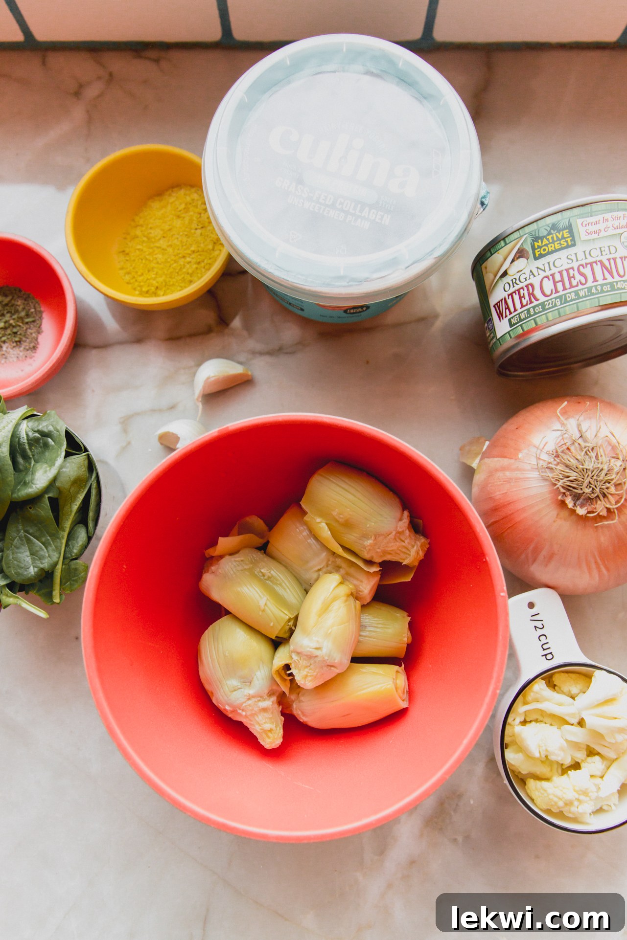 All the fresh ingredients needed to make spinach & artichoke dip laid out on a counter before cooking.