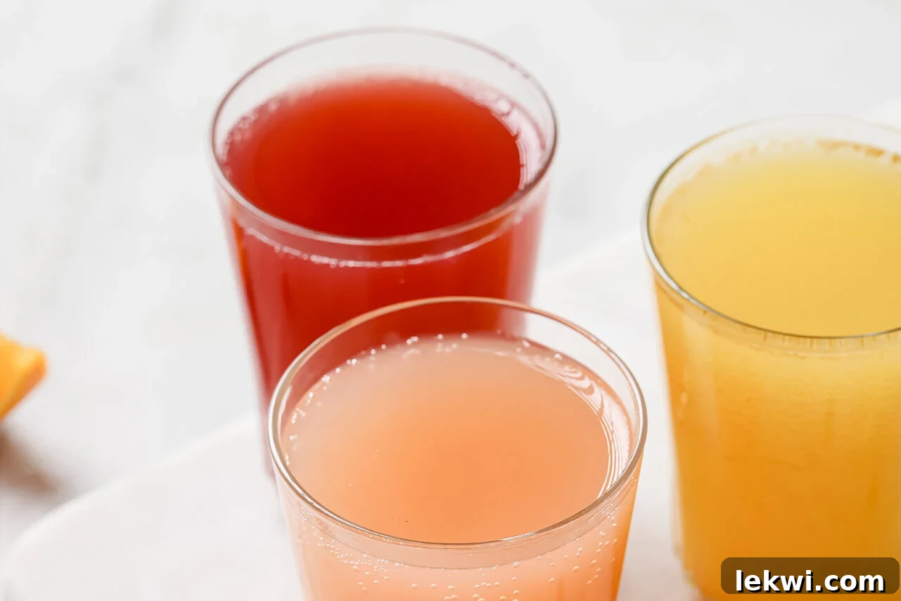 Three beautifully presented glasses with diluted, flavored apple cider vinegar shots, garnished and ready to be enjoyed.
